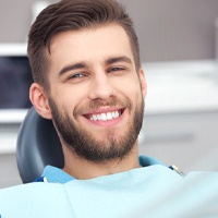 Man with brown hair smiling after getting cosmetic dentistry