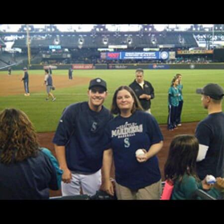 Team member posing with Mariners player