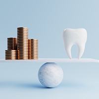 tooth balanced with coins to represent cost of tooth extractions