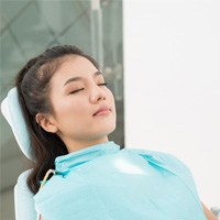 Female dental patient sitting back and relaxing in dental chair