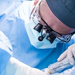 A dentist performing dental implant surgery on a patient