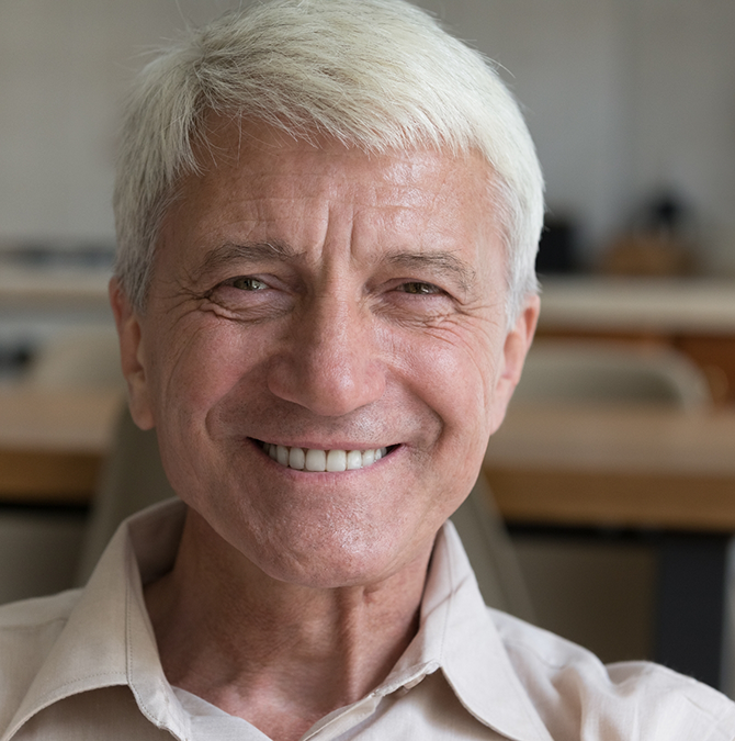 Smiling senior man in a white collared shirt