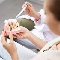 a dentist explaining how dental implants work to a patient