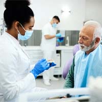 a dentist showing a patient a model of dental implants