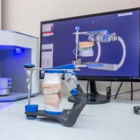 a dental laboratory with a computer screen and model of a mouth