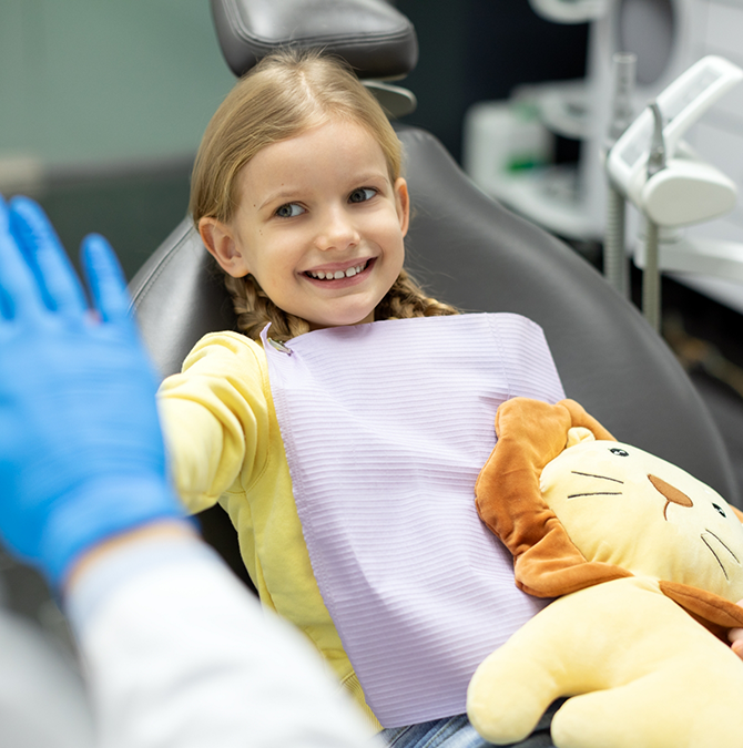 Young girl giving a high five to her dentist