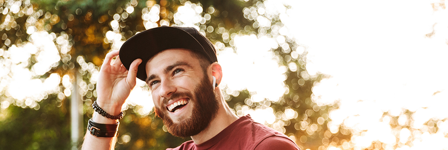 Young man with a beard smiling in the sunlight