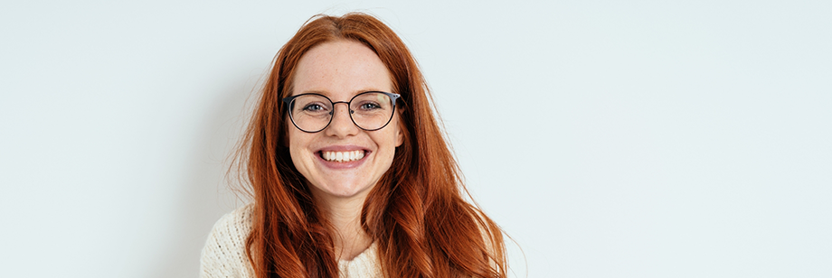 Redheaded young woman grinning with dental crowns in Bellingham