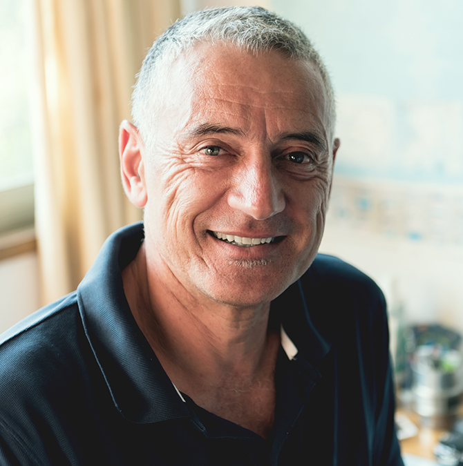 Smiling older man in a navy blue collared shirt