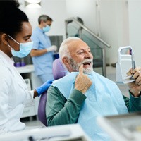 man smiling after getting dentures 