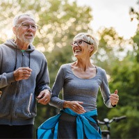 senior couple jogging in park 