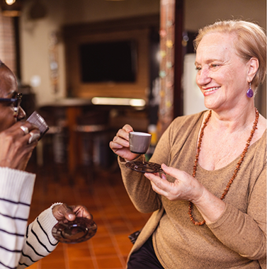 Two older women drinking tea together
