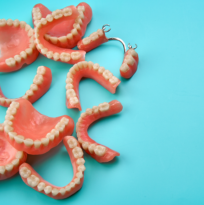 Several dentures against a light blue background
