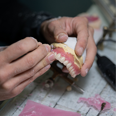 Dental lab technician working on a denture