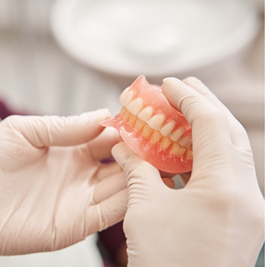 Dentist holding a set of full dentures