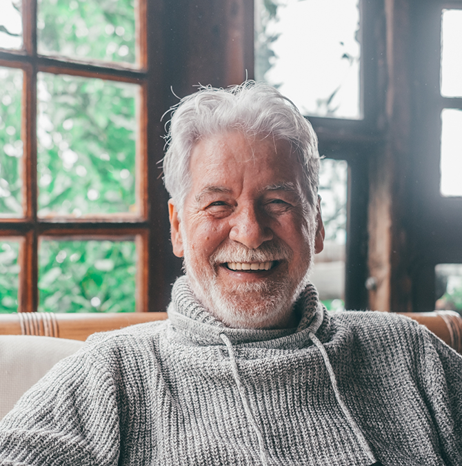 Smiling senior man in a gray sweater