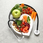 healthy foods arranged on a heart-shaped plate with a stethoscope around it