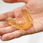 a person holding a mouthguard in their hand