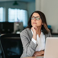 Woman thinking about visiting her Bellingham emergency dentist