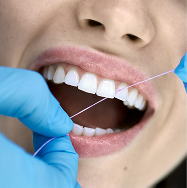 Close up of a person flossing their teeth