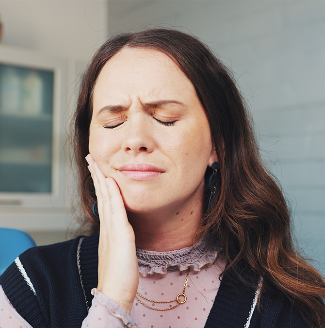 Woman holding her cheek in pain