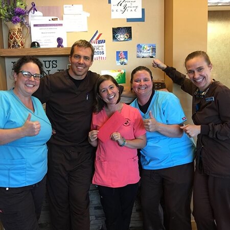 Dental team and patient with gift