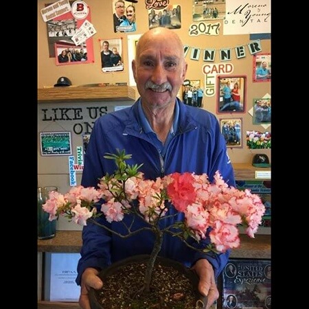 Older male patient holding a plant