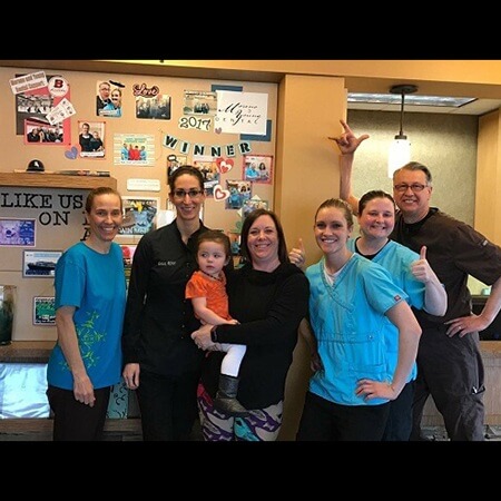 Dental team and patient smiling together