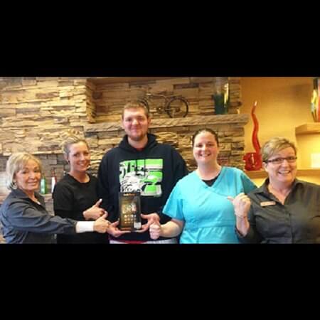 Dental team and young man with prize