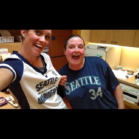 Two dental team members in Seattle mariners jerseys