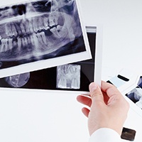 a dentist looking through dental X-rays