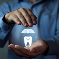 a person covering a tooth with an umbrella