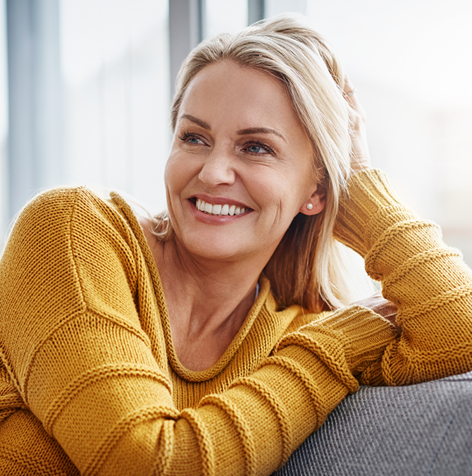 Smiling blonde woman in a yellow sweater
