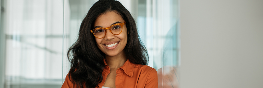 Woman in an orange blouse smiling after gum recontouring in Bellingham