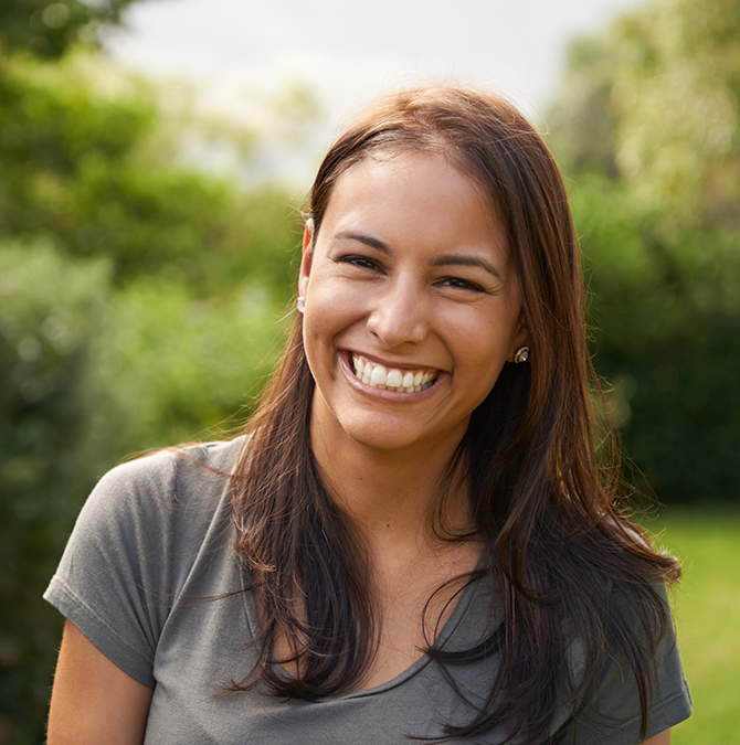 Brunette woman grinning outdoors