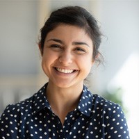 Woman with spotted shirt smiling at home 