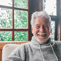 Man in grey sweater smiling in cabin