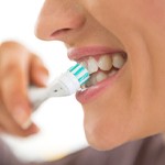 Closeup of woman brushing her top row of teeth