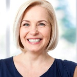 Woman with shorter hair smiling in navy blue top