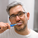 man brushing his teeth 
