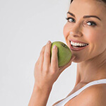 woman biting into a green apple 