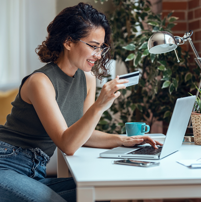 Woman entering her credit card information into a laptop