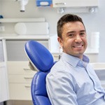 Man sitting in dental chair and smiling