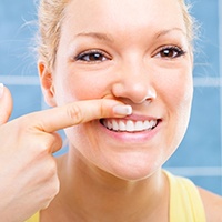 Woman raising lip to look at gums