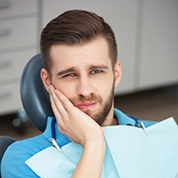 Man in pain holding his cheek