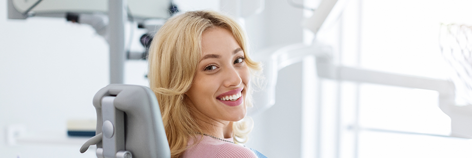 Woman in the dental chair smiling over her shoulder