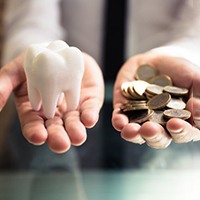 Person balancing a tooth with a pile of coins