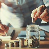 Person putting coins into a jar