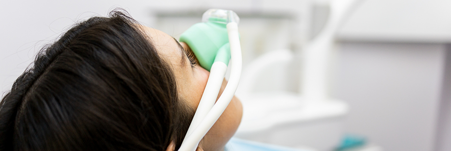 Woman in the dental chair with a nitrous oxide mask on her face