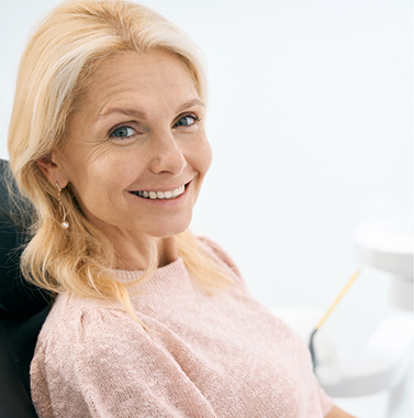 Smiling older blonde woman in the dental chair